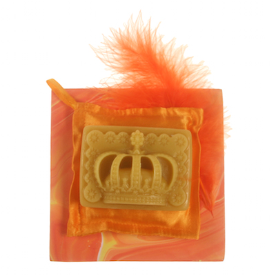 Een grote kroon op een zacht oranje geurkussentje